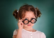 Little girl with thick bottle glasses on green background Little girl with thick bottle glasses on green background