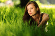 brunette lying on green grass