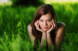 brunette lying on green grass