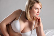 Beautiful blonde woman in bed with sexy cleavage