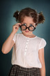 Little girl with thick bottle glasses on green background Little girl with thick bottle glasses on green background