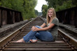Beautiful young blond model posing on railroad tracks