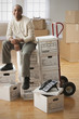 African man sitting on moving boxes