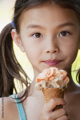 Foto: Mixed race girl eating ice cream cone Mixed race girl eating ice cream cone