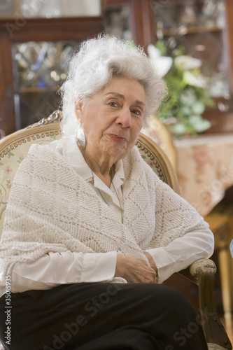 Photo: Senior Hispanic woman sitting in chair Senior Hispanic woman sitting in chair