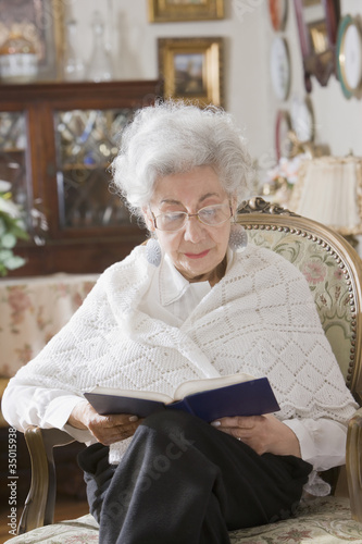 Photo: Senior Hispanic woman reading book Senior Hispanic woman reading book