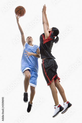 Photo: Mixed race women playing basketball Mixed race women playing basketball