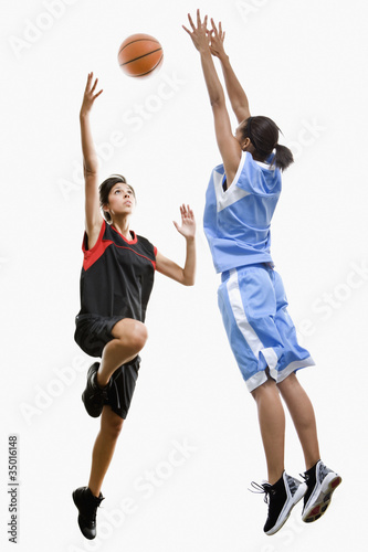 Photo: Mixed race women playing basketball Mixed race women playing basketball