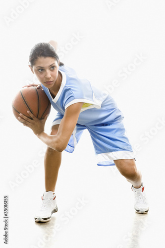 Photo: Mixed race woman playing basketball Mixed race woman playing basketball