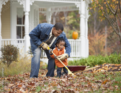 Photo: Black father and daughter raking leaves Black father and daughter raking leaves