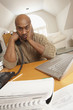 Photo: Frustrated black man working in home office Frustrated black man working in home office