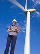 Mixed race businesswoman standing near wind turbine