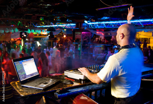 Photo: Dj mixes the track in the nightclub at a party Dj mixes the track in the nightclub at a party
