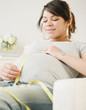 Pregnant Hispanic woman measuring stomach