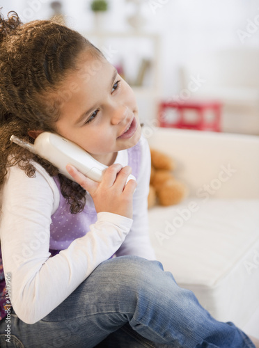 Photo: Hispanic girl talking on telephone Hispanic girl talking on telephone