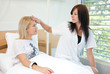 Nurse looking at whether the patient is febrile