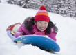 Laughing Japanese girl sledding