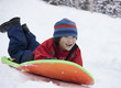 Laughing Japanese boy sledding