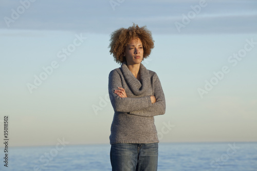 Photo: Black woman standing near ocean Black woman standing near ocean