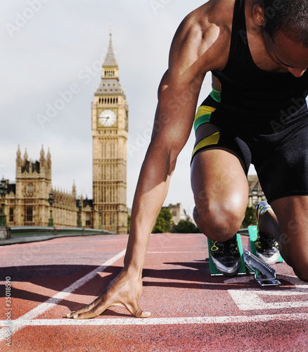 Foto: Black runner kneeling at starting block Black runner kneeling at starting block