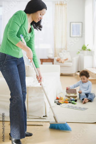 Foto: Mixed race mother sweeping floor Mixed race mother sweeping floor