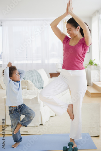 Photo: Mixed race mother and son practicing yoga Mixed race mother and son practicing yoga