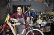 Hispanic man assembling bicycle in shop