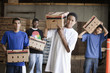 Men carrying cardboard boxes in warehouse