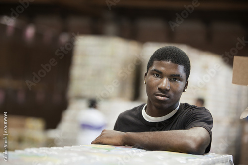 Photo: Black man standing in warehouse Black man standing in warehouse