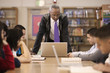 Librarian helping students in school library