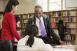 Librarian helping students in school library