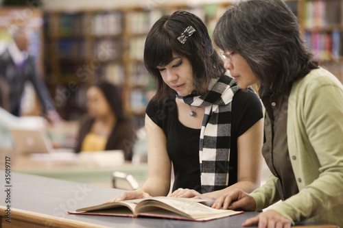 Photo: Filipino librarian helping student in school library Filipino librarian helping student in school library