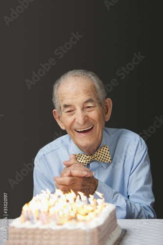 Photo: Senior Hispanic man blowing out birthday candles Senior Hispanic man blowing out birthday candles