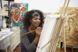 Mixed race artist painting in studio