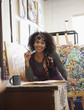 Foto: Mixed race artist working in studio Mixed race artist working in studio