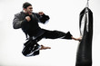 African American man karate kicking bag