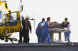 Medical personnel rushing patient from helicopter