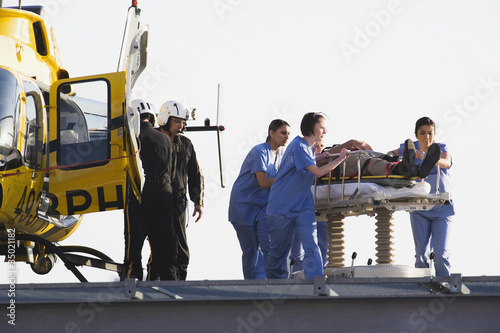 Photo: Medical personnel rushing patient from helicopter Medical personnel rushing patient from helicopter