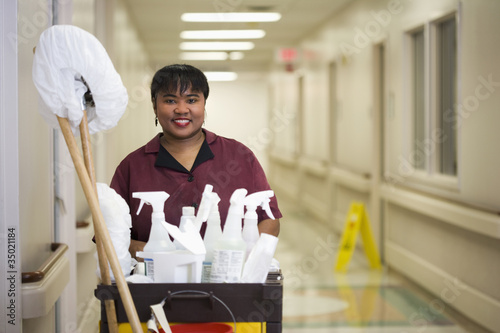 Photo: Janitorial worker with cart in hospital hallway Janitorial worker with cart in hospital hallway