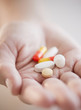 Hand holding pills and capsules