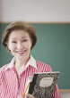Japanese woman holding books in classroom