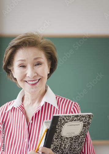 Photo: Japanese woman holding books in classroom Japanese woman holding books in classroom