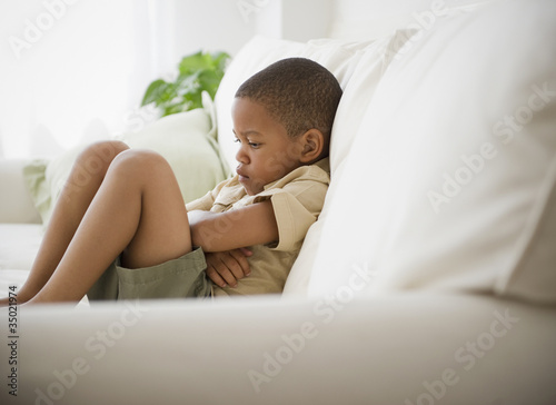 Foto: African American boy unhappy on sofa African American boy unhappy on sofa
