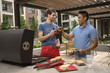 Men toasting with beer at barbecue on patio