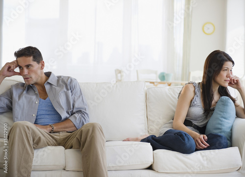 Photo: Angry mixed race couple having argument on sofa Angry mixed race couple having argument on sofa