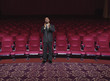 Hispanic businessman clapping in empty theater