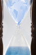 Globe squeezing through hour glass