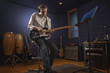 Caucasian man playing guitar in studio
