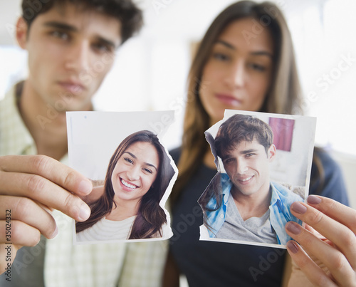 Photo: Couple holding torn photograph Couple holding torn photograph