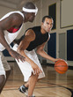 Men playing basketball on basketball court
